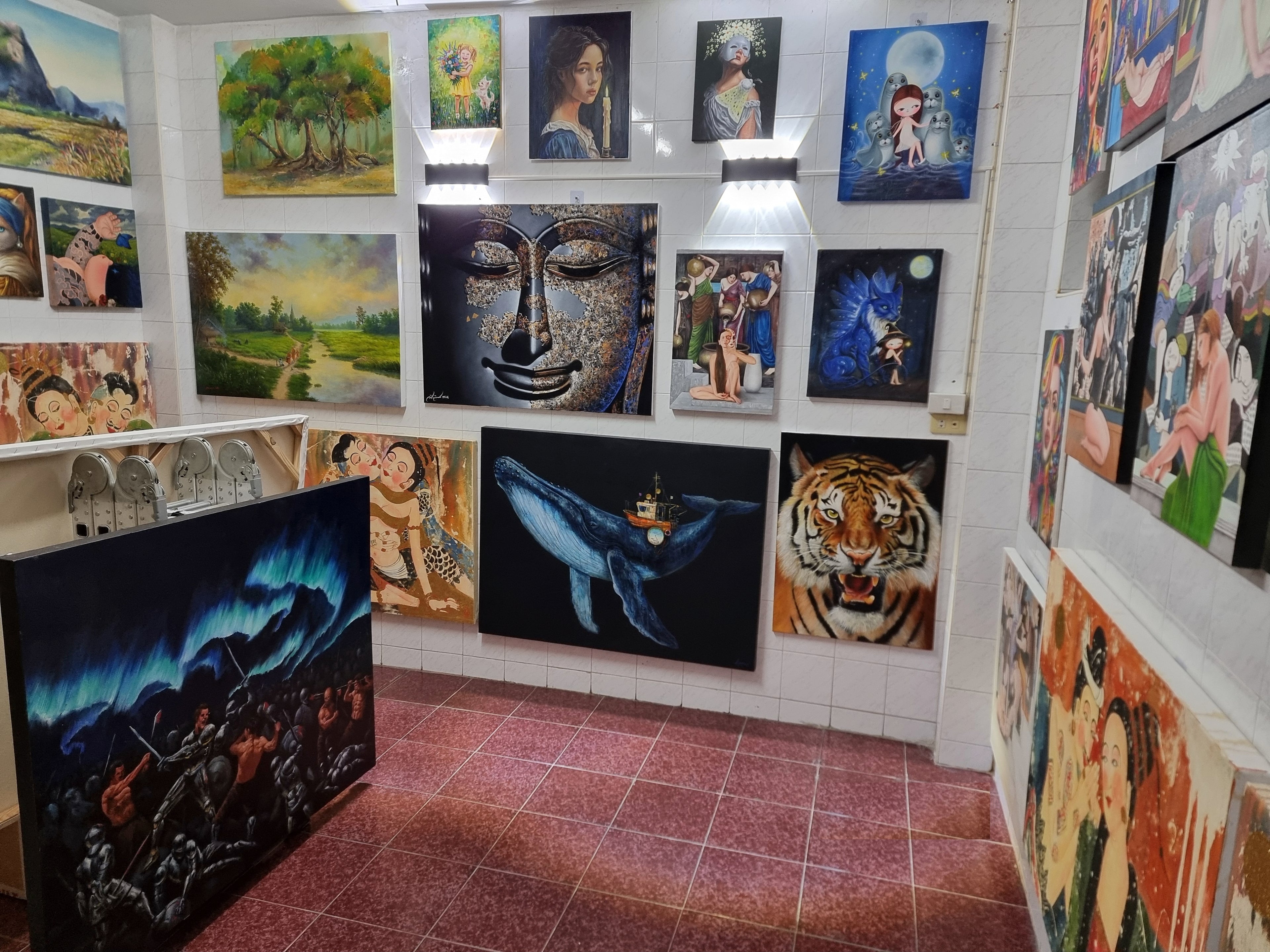 Art gallery with various paintings on the walls and floor.